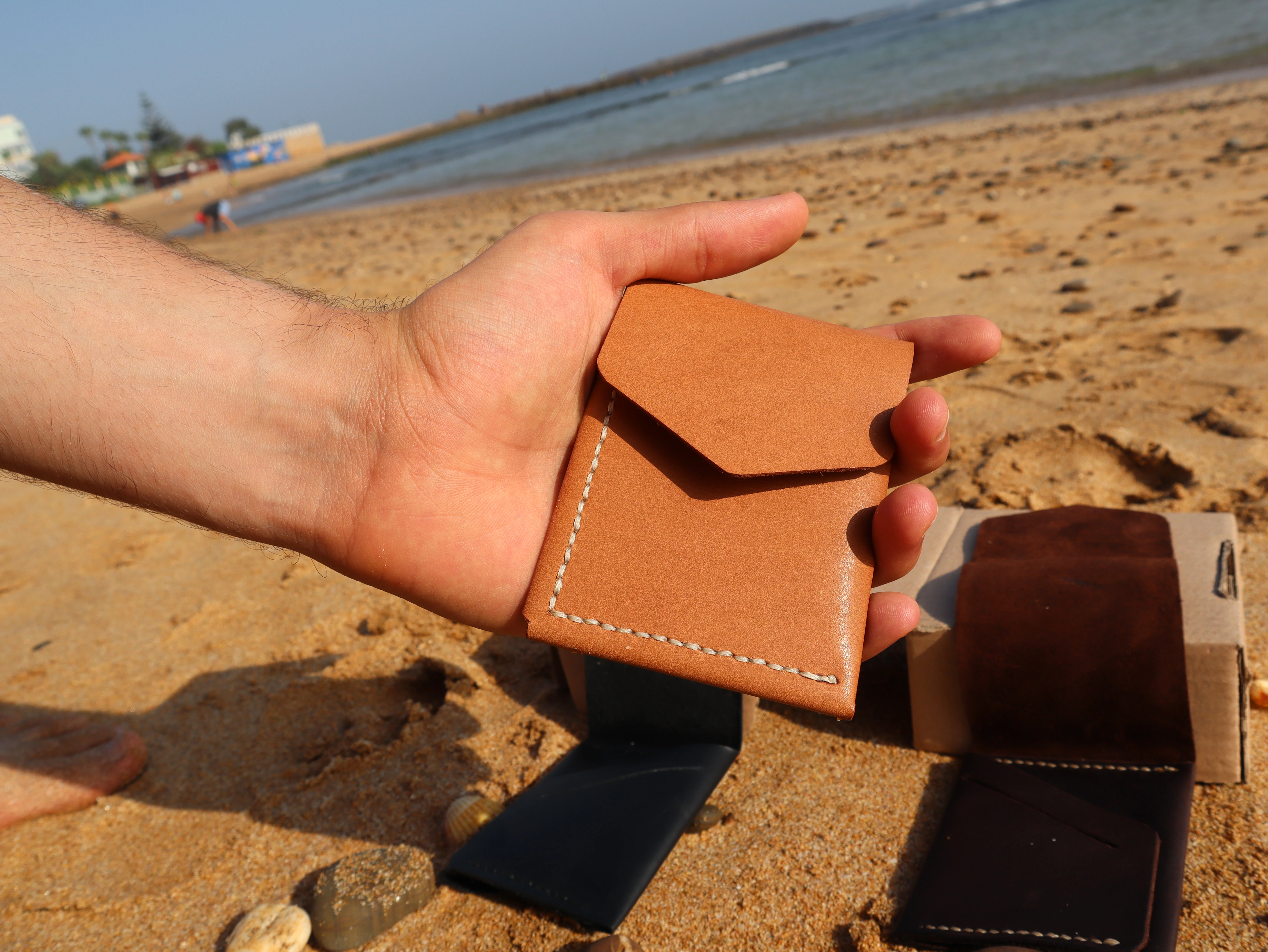 Porte-cartes Atlas en cuir Beige avec couture noire, tenu en main