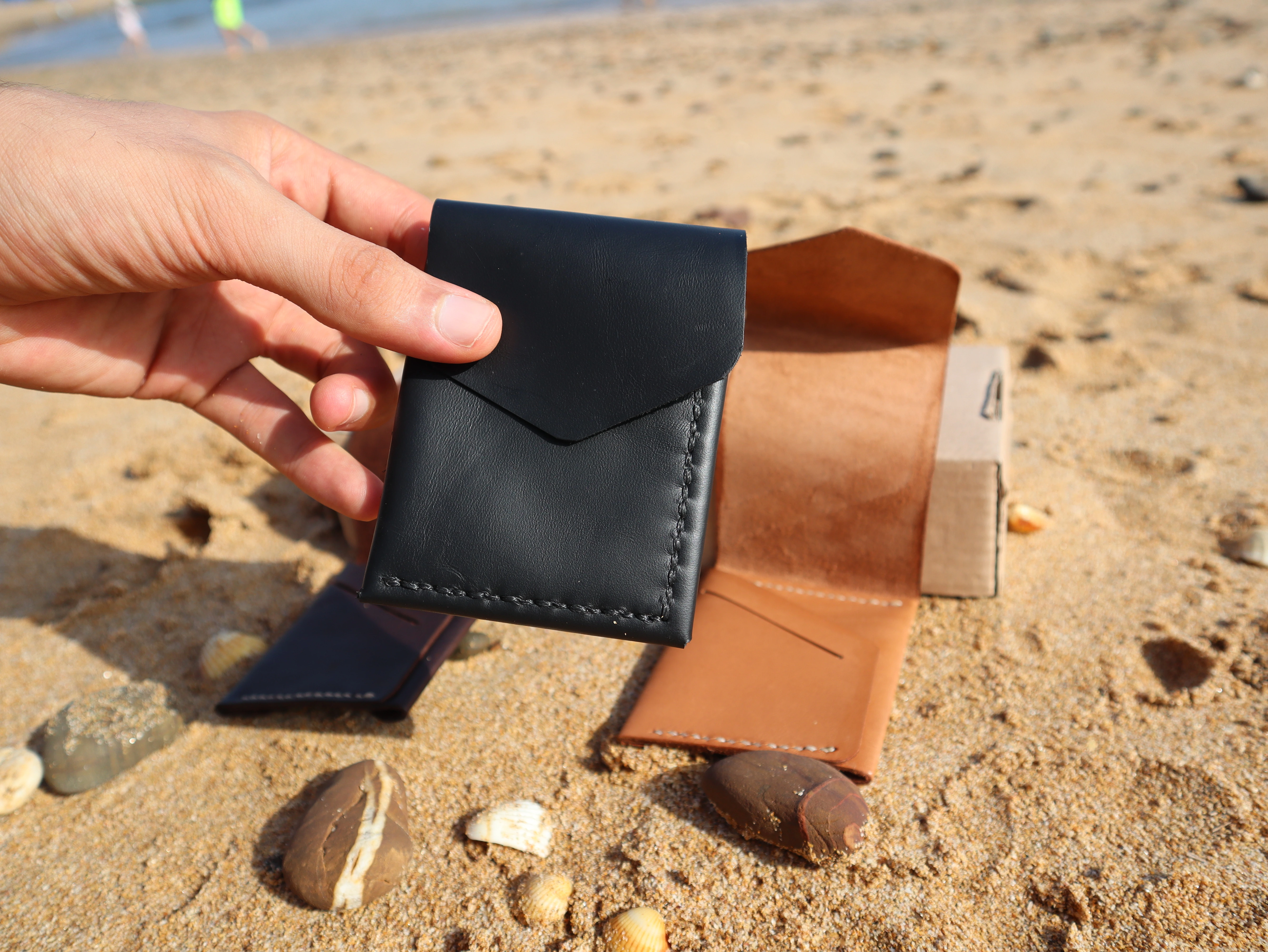 Porte-cartes Atlas en cuir Noir, tenu en main